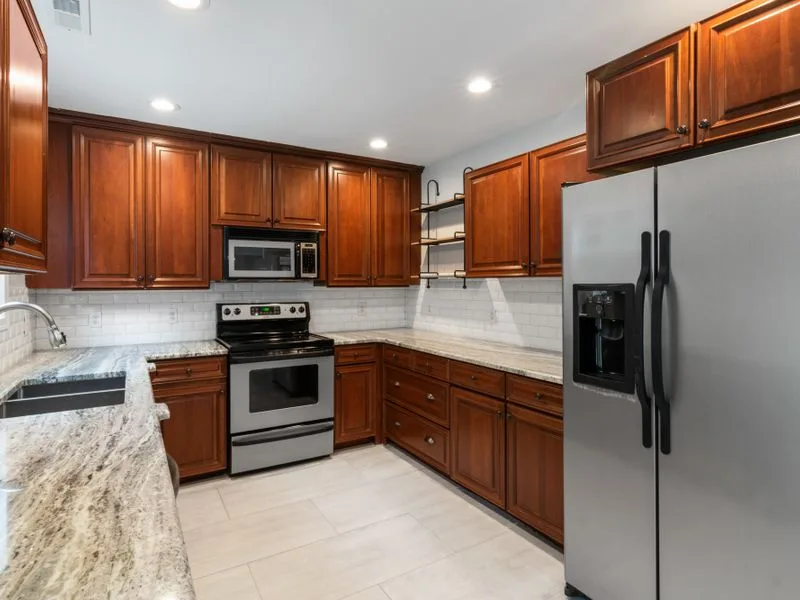 Renovated kitchen with wood cabinetry and granite counters