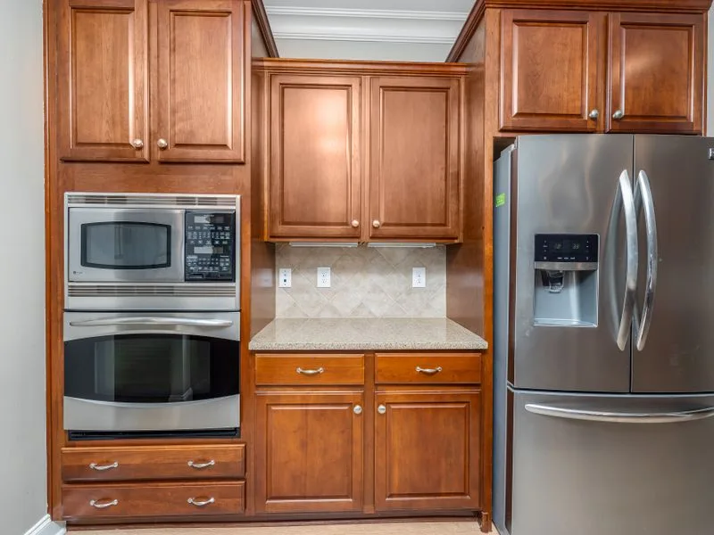 Refinished wood kitchen cabinets with stainless appliances