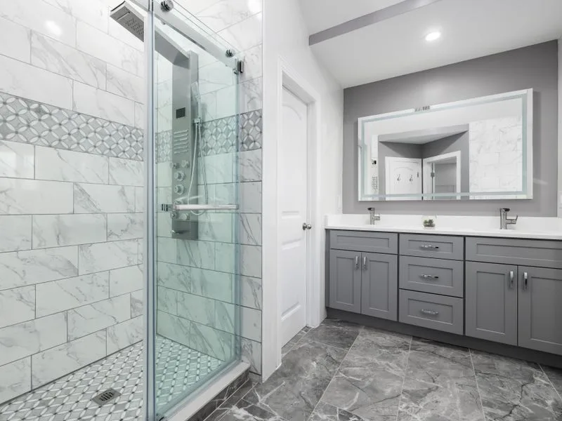 Renovated bathroom with a glass walk-in shower and double vanity