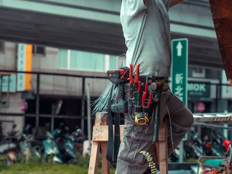 Tradesperson wearing a tool belt working on a home repair